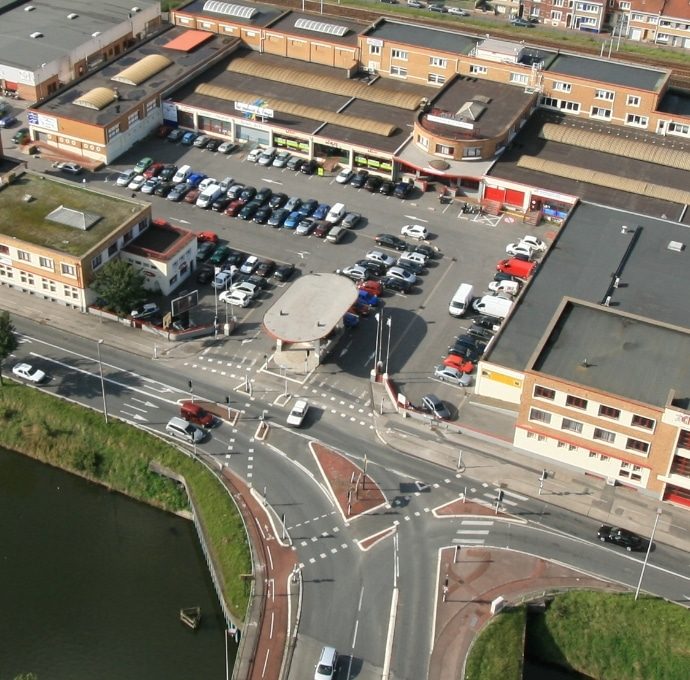 Vue aérienne du site CREANOR à Coudekerque-Branche : les halls, la barre commerciale, le parking central, l'immeuble de bureaux et le rond-point de la route de Bergues